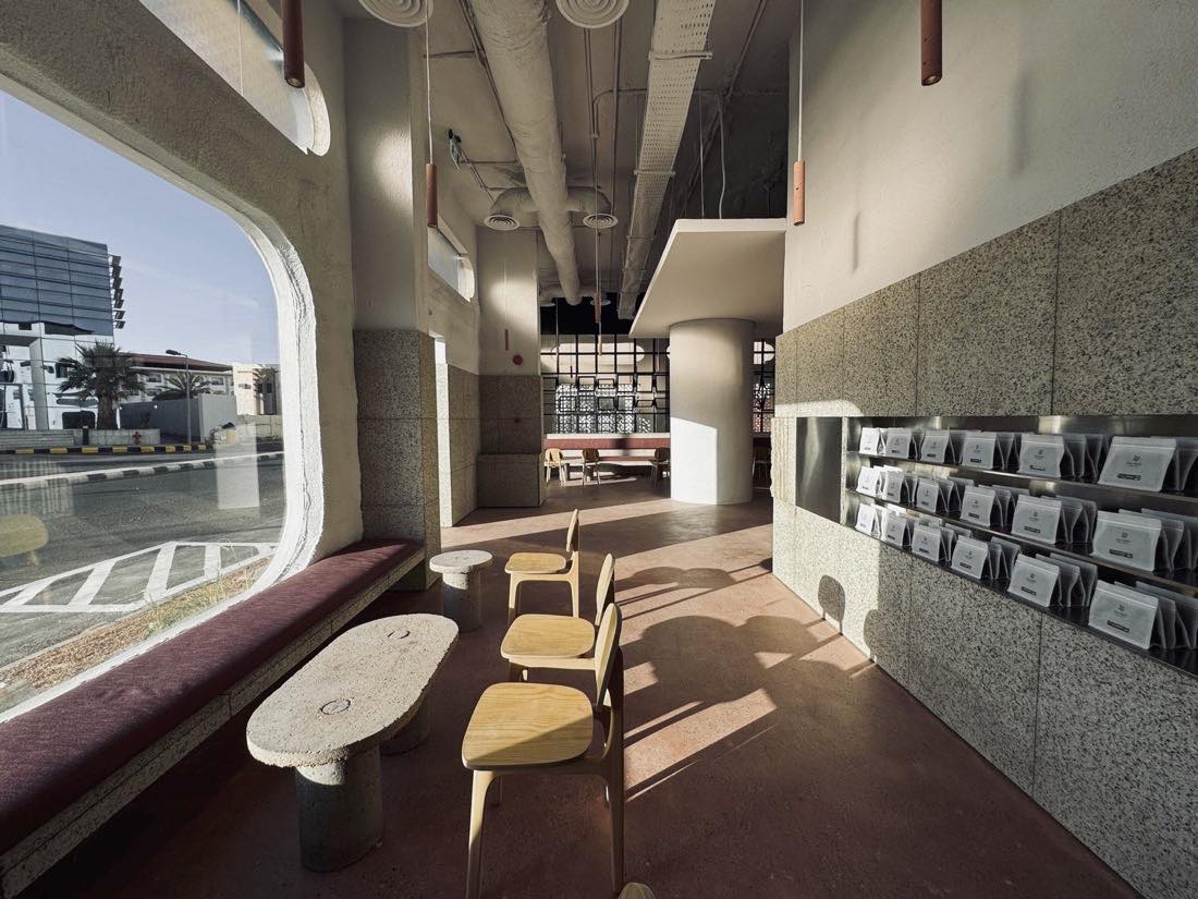 Daylight interior of Camel Step with a wall of bean pouches, terrazzo, and wood chairs